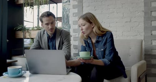 Business people sitting in cafe having meeting with laptop and drinking coffee