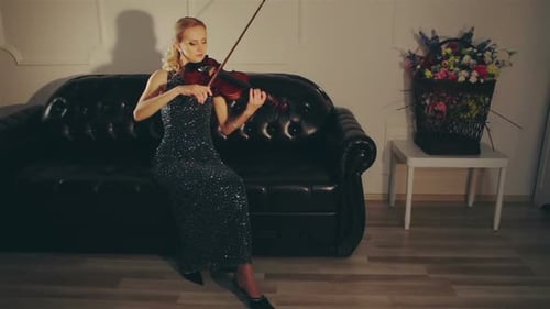 Elegant Woman Playing Violin on Leather Sofa