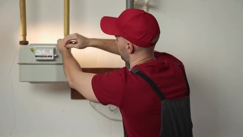 Skilled Technician Performs Gas Meter Maintenance in a Residential Building