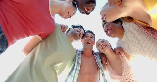 Smiling Friends Huddle Together on Sunny Beach