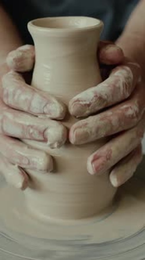 Close-up of Soft Hands of Unrecognisable Potter Forming Clay Vase