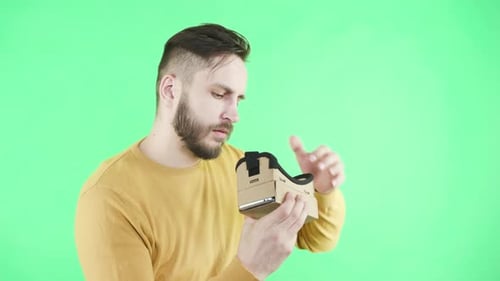 Man Assembling and Using Cardboard Virtual Reality Viewer