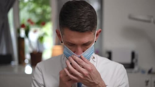 Young Man Puts on a Surgical Mask