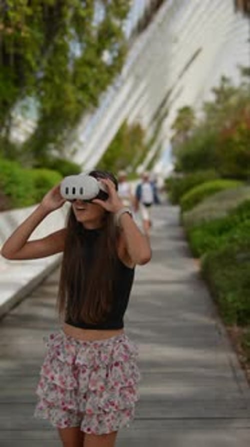 A Woman Wearing a VR Headset is Fully Immersed in Nature Exploring a Vibrant and Lush Garden