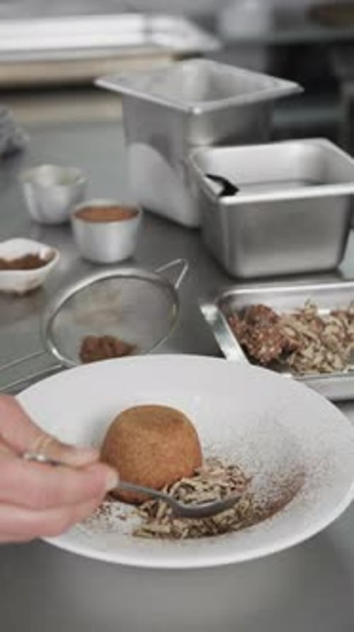 Caucasian male chef putting meal on white plate in kitchen, slow motion, vertical
