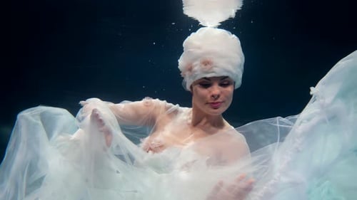 Fabelhaftes Unterwasserfoto einer schönen Frau, die in der Tiefe schwimmt Romantisches Märchen