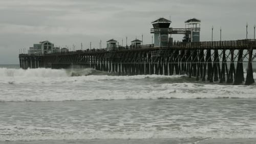 Waves crash into the pier in Oceanside, California.