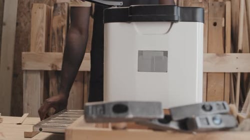Carpenter Using Electric Planer in Workshop