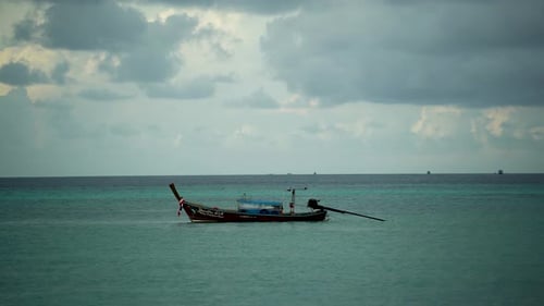Thai Wooden Boat with Motors Drifting at Anchor in the Sea