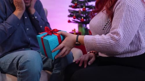 Woman Presents Christmas Gift to Excited Partner