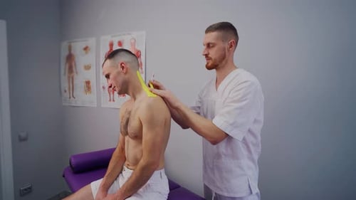 Doctor Applies Tape to Patient in Examination Room
