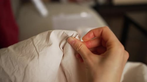 Woman Sewing Fabric with Needle and Thread, Close-Up