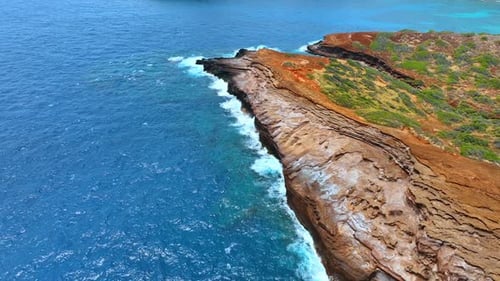 Azure waterscape of the Pacific Ocean at the bare rocky shore of Hawaii, USA.