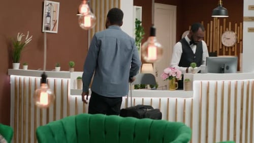 Hotel Receptionists Greeting Guest in Bright Lobby