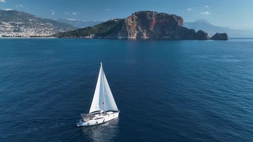 Sailboat Floating on Rippling Blue Sea Aerial View