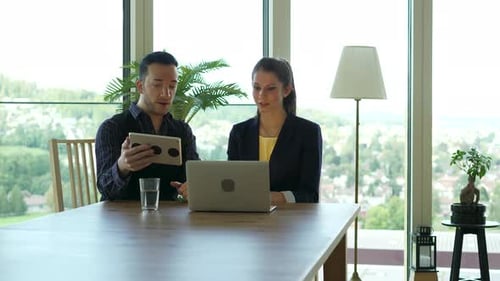 Two Young Business People Meeting in Office Talking Together