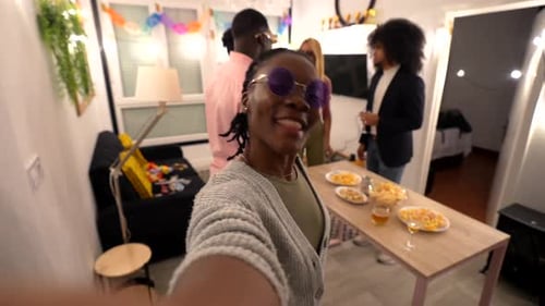 Mulher tirando uma selfie com amigos na festa em casa