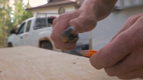 A Contractor Sharpens His Pencil Using A Knife