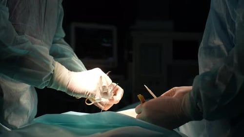 Nahaufnahme eines nicht wiederzuerkennenden Ärzteteams von Chirurgen im Krankenhaus, das invasive Operationen durchführt