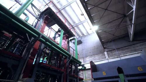 Low Angle Shot Motion Along Plant Workshop with Pipelines