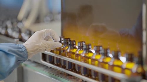 Une personne vérifiant la qualité des bouteilles de sirop.