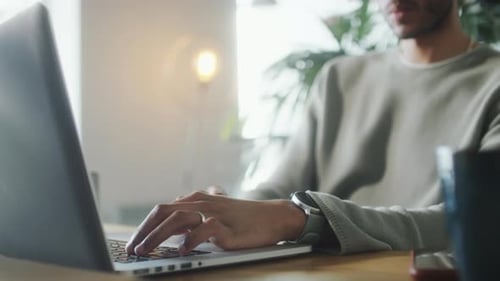 Young Adult Typing on Laptop in Modern Home
