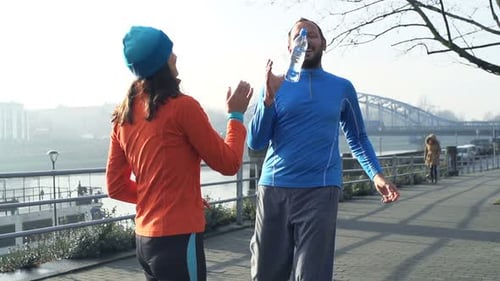Couple Drinking Water After Jogging in City, Super 240