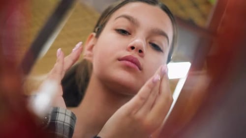Young Woman Touching Face in Mirror Close Up