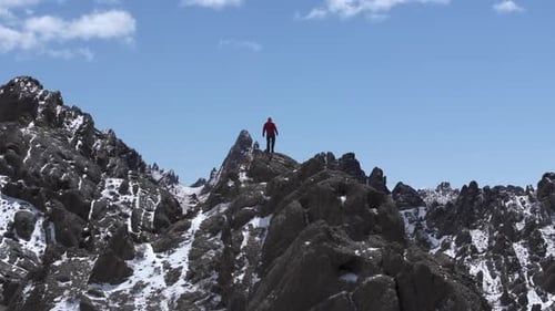 Hiking Man Overlooking Snowy Mountain Landscape with Clouds and Mountain Range