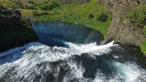 Scenic Aerial of Waterfall with Rainbow and Cliffs