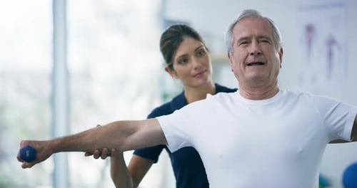 4k video footage of an attractive young female physiotherapist working with a senior male patient