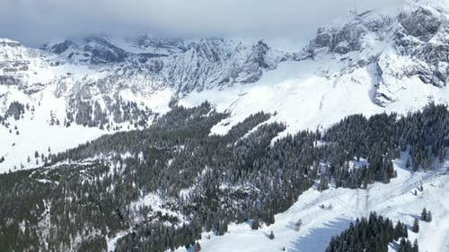 Fronalpstock mountains under heavy clouds in Glarus, Switzerland. Aerial view.