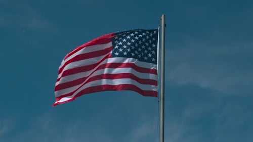 American Flag Waving Proudly Against Blue Sky