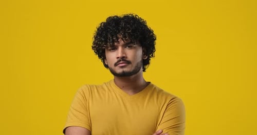 Young Indian Man Thinking with Hand Near Chin Standing Over Studio Background