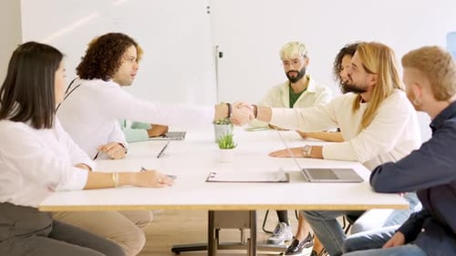 Homens apertando as mãos fechando um negócio em uma sala de reuniões