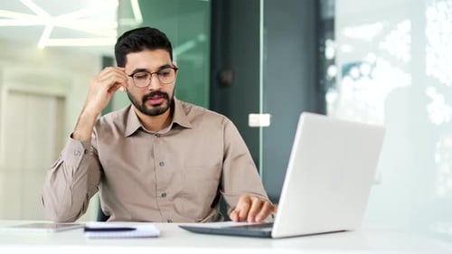 Exhausted Professional Rubbing Eyes at Desk