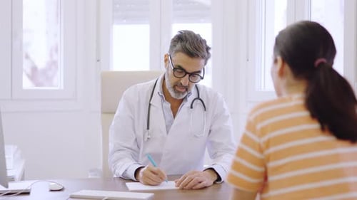 Doctor Consulting With Patient in Bright Office