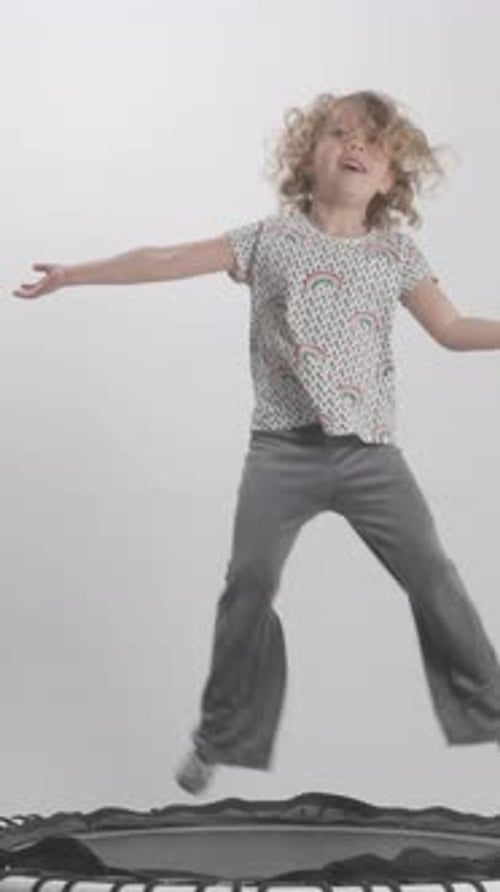 Young Child Happily Jumping on a Trampoline