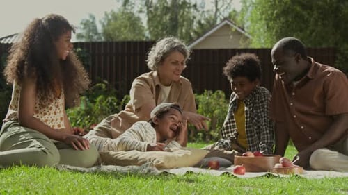 Family Relaxing Together at Picnic in the Yard