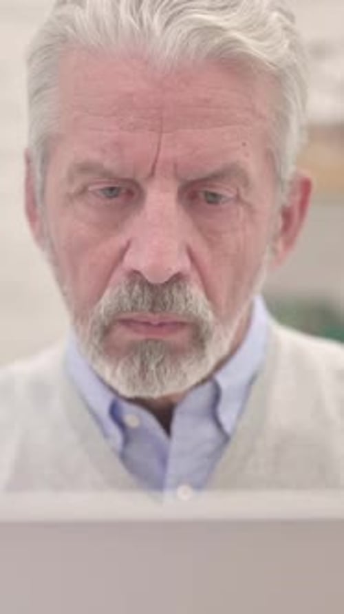Close Up of Thinking Old Man Working on Laptop, Vertical Video