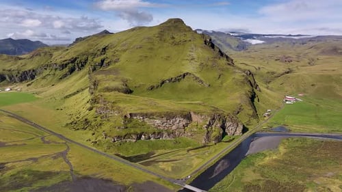 Aerial view of Skógafoss waterfall in Iceland, with powerful cascade dropping over cliff, mist