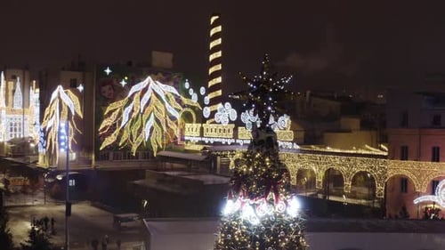 New Year's lighting in the city square. You can see the ice rink, buildings and city streets.