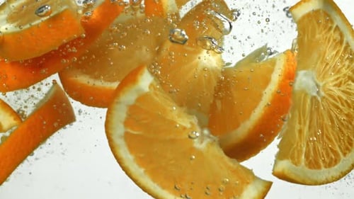Pieces of Oranges Falling Under Water on a White Background Filmed on a Highspeed Camera at 1000 Fps