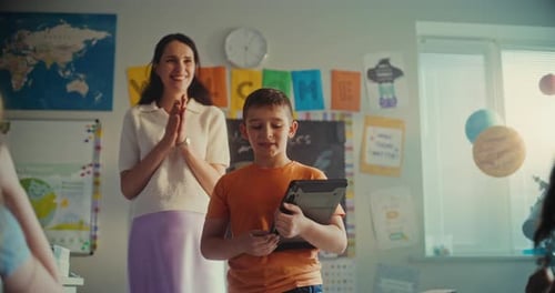 Primary School Boy with Digital Tablet Showcasing Knowledge of Renewable Energy in Front of Class