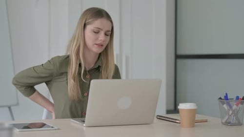 Woman Experiencing Back Pain at Desk Job