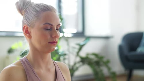 Woman Meditates Calmly in Lotus Position Indoors