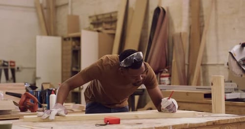 4k video footage of a young
male builder measuring pieces in his carpentry workshop