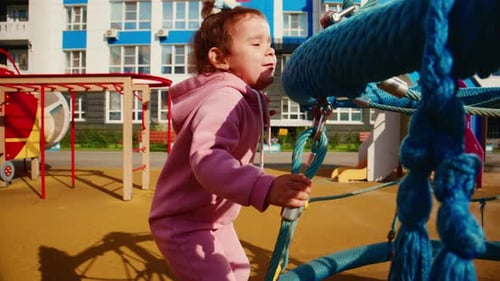 Ein kleines Kind genießt es, auf einem farbenfrohen Spielplatz zu spielen und zu klettern und zu erkunden, während es sich entwickelt