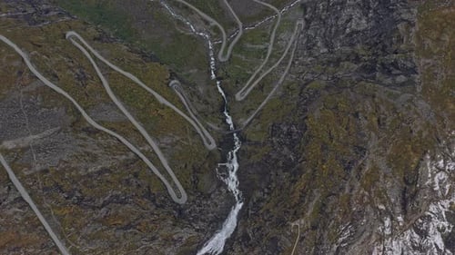 Vista de cima para baixo de veículos ziguezagueando na rodovia montanhosa Trollstigen