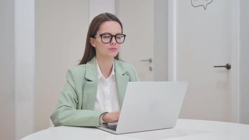 Young Woman Working on Laptop in Office